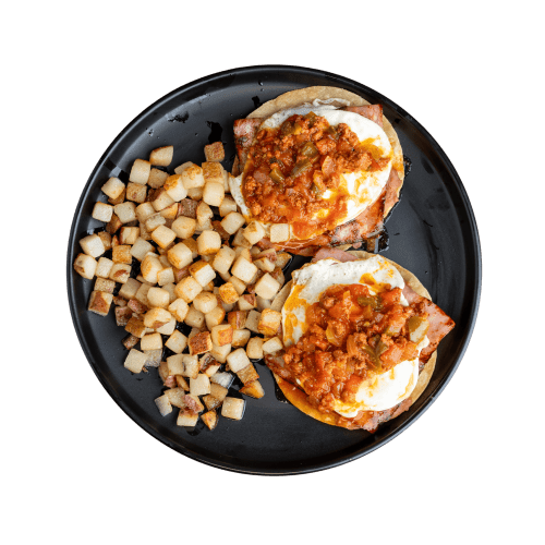 Crispy tostada topped with sunny-side-up eggs, potatoes