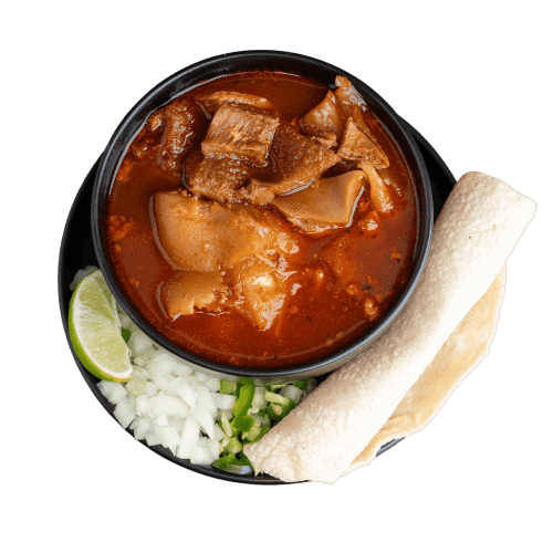 Traditional Mexican menudo served with lime, onion, and oregano.